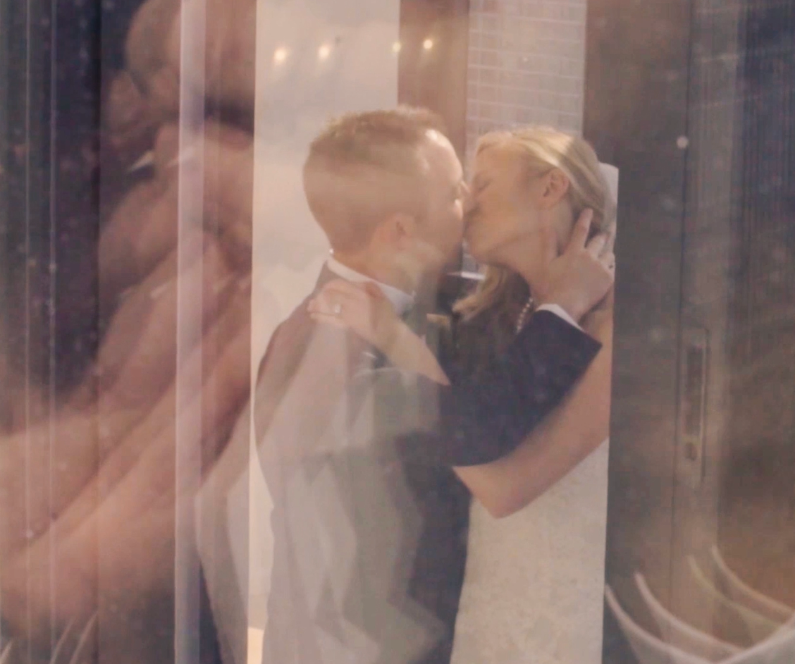 Layered cinematic reflection of a newly married couple kissing