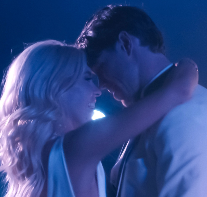 Newly married couple embracing beneath purple-blue evening light