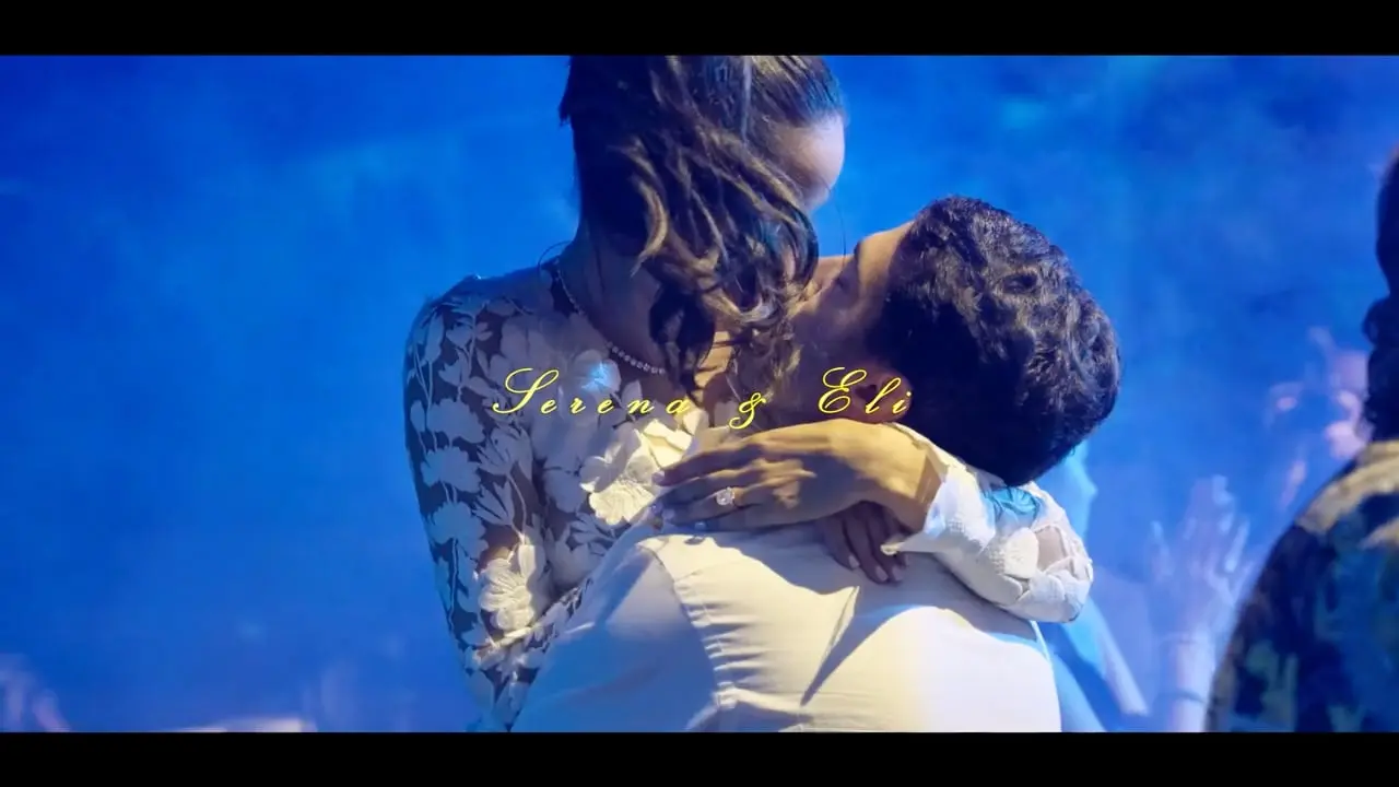 Serena and Eli embracing beneath blue reception light